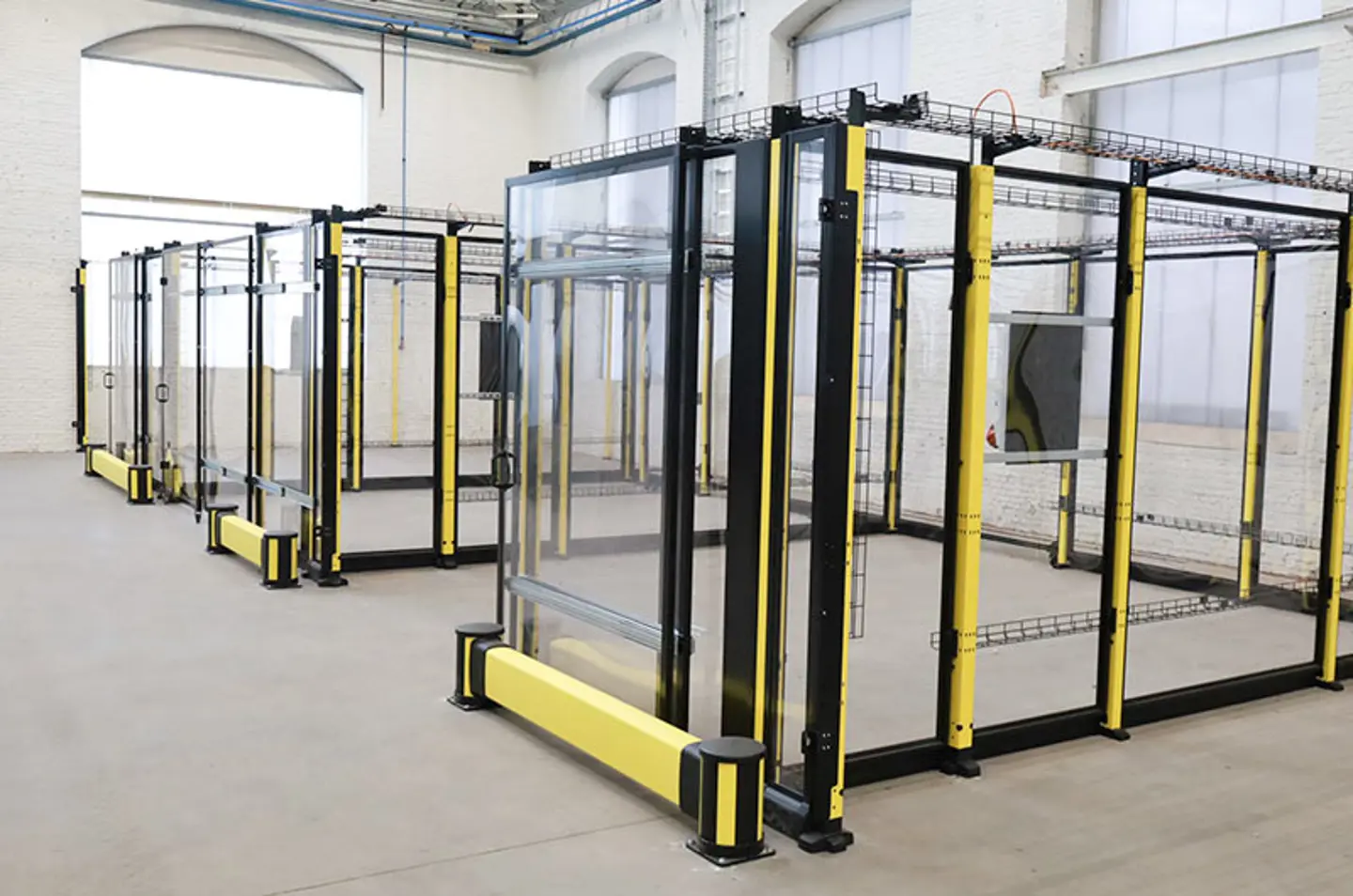 Machine guarding cells with clear polycarbonate panels. They are currently empty inside ready for new machinery.