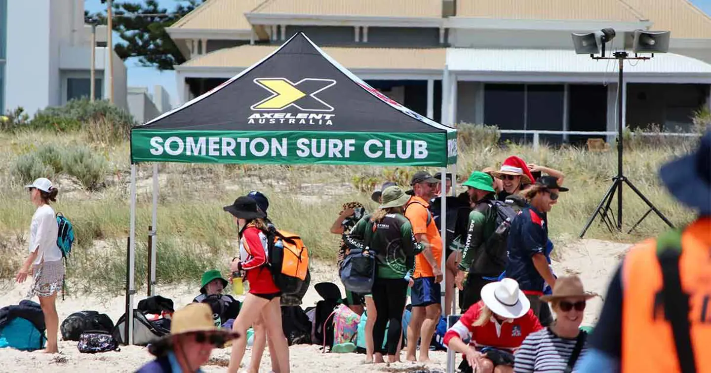 Somerton surf club members under a gazebo on a sandy beach